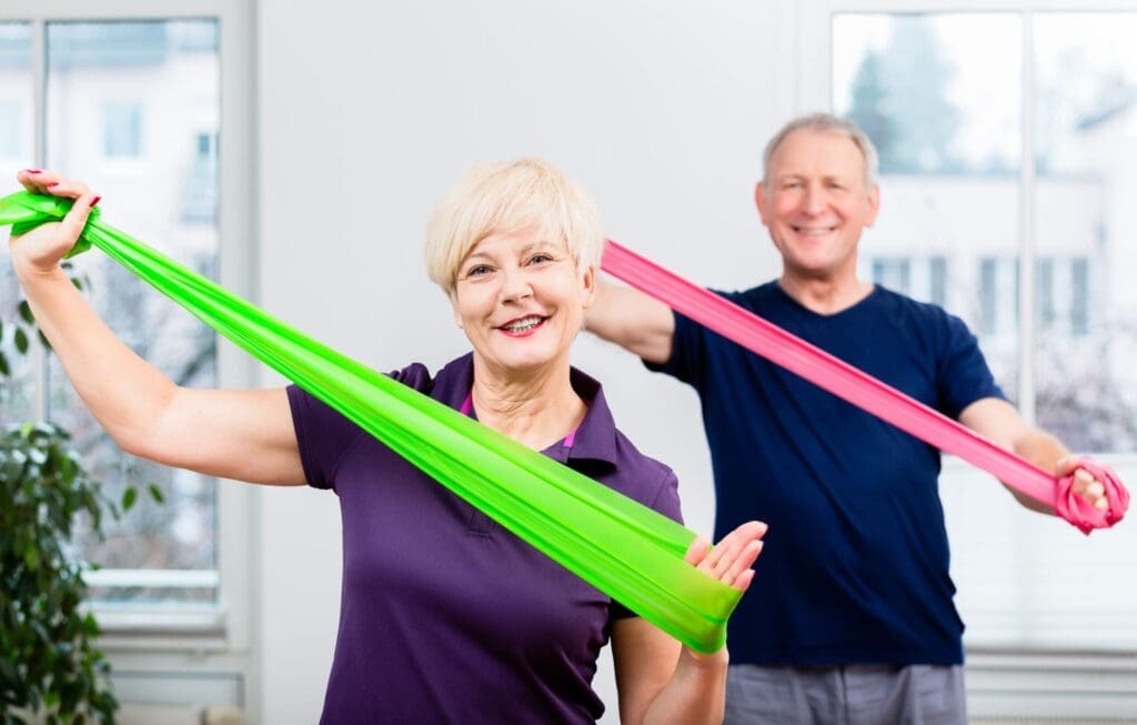 Older patients in physiotherapy session using Theraband for strength training